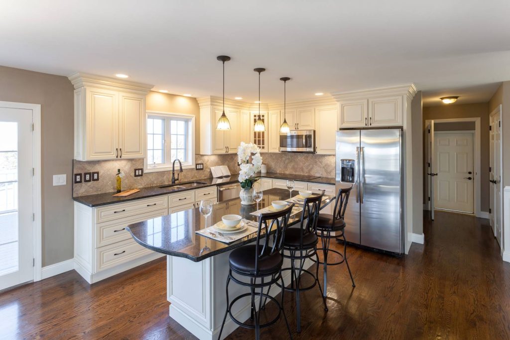 Modern kitchen remodel in Tupelo MS featuring white shaker cabinets, quartz countertops, and island seating.